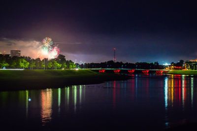 View of firework display over river at night