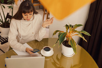 Woman home office and distance remote working. a young female businesswoman sitting at a desk 