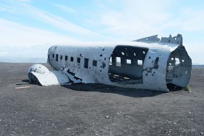 Abandoned airplane on runway against sky