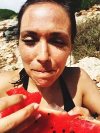 Woman eating watermelon outdoors