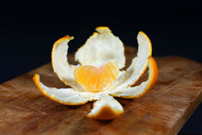 Ones piece of mandarin in the remaining in the peel close up