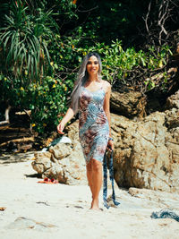 Portrait of young trans woman standing at beach