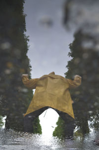 Rear view of person in puddle during rainy season