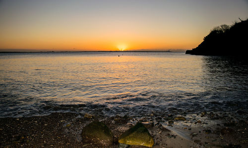 Scenic view of sea against clear sky during sunset