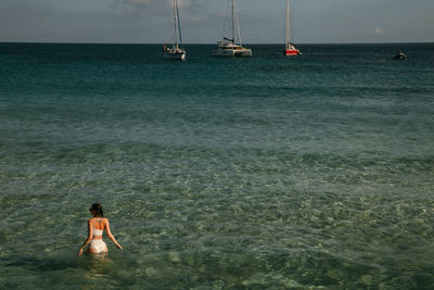 Rear view of woman in sea against sky