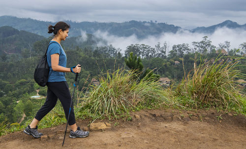 Woman hiking to the top of adma's peak close to ella in sri lanka