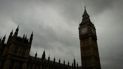 Low angle view of clock tower against cloudy sky