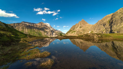 Scenic view of lake and mountains against blue sky