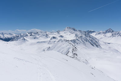 Scenic view of snowcapped mountains against clear blue sky