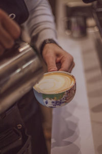 Midsection of woman holding coffee on table