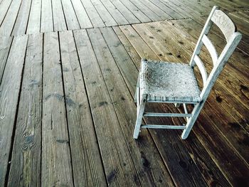 High angle view of white empty chair on boardwalk