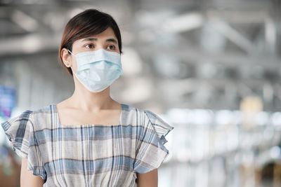 Close-up of woman wearing mask standing at airport