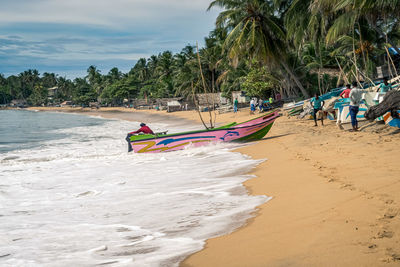 People on beach against sky