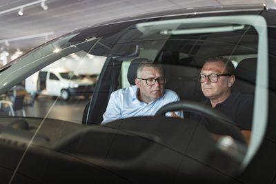 Men in car showroom