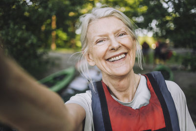 Happy senior woman taking selfie wearing life jacket