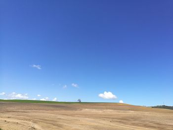 Scenic view of desert against blue sky