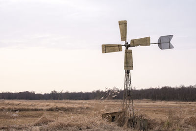 Windmill on field against sky