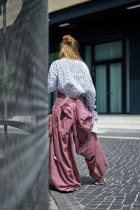 Rear view of woman standing on footpath