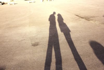 Shadow of man and woman standing on street