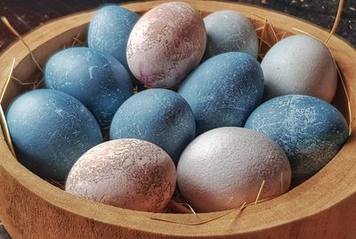 High angle view of multi colored eggs in container