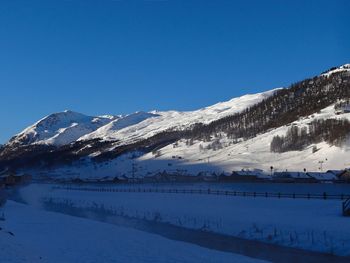 Scenic view of snowcapped mountains against clear blue sky