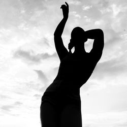 Low angle view of silhouette woman standing against sky