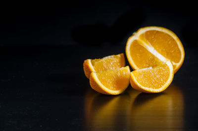 Close-up of sliced oranges on table against black background