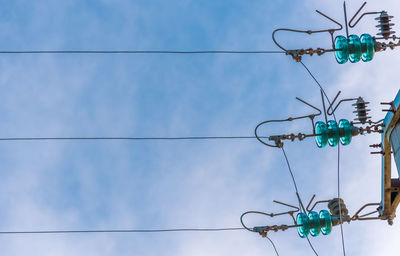 Low angle view of telephone pole against blue sky