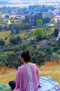 Rear view of woman sitting on hill