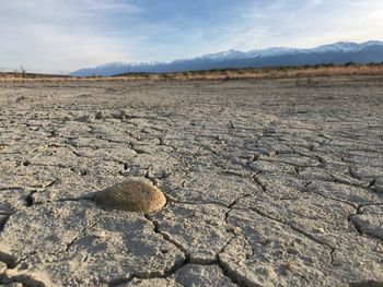 Surface level of barren land against sky