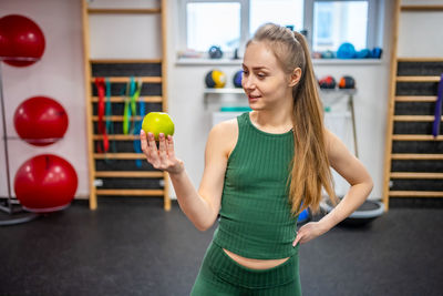 Portrait of smiling young woman exercising in gym