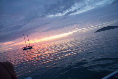 Boat sailing in sea at sunset