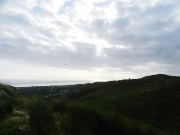 Scenic view of landscape against cloudy sky