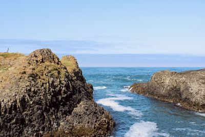 Scenic view of rocks in sea against sky