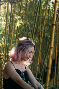 Close-up of young woman with closed eyes sitting in forest