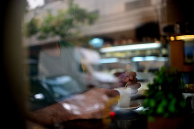 Man having coffee in cafe seen through window