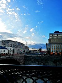 Train by buildings in city against sky