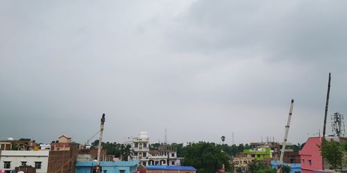 Buildings in city against cloudy sky