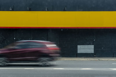 Blurred motion of yellow car on road