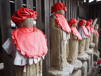 Rear view of friends standing against red wall