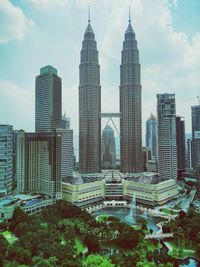 Low angle view of tall buildings against clouds