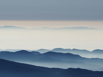 Scenic view of mountains against sky with fog