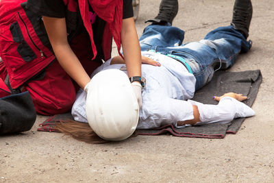 Paramedic performing cpr on person women on street