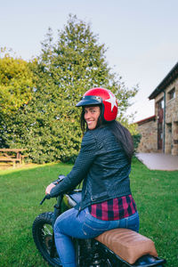 Portrait of woman riding motorcycle on lawn