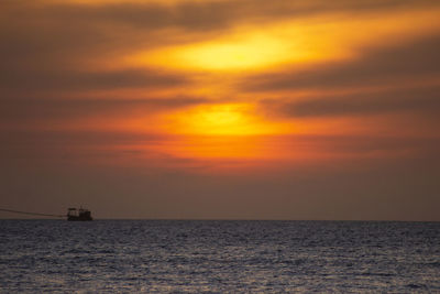 Scenic view of sea against orange sky