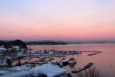 High angle view of boats moored at harbor during sunset