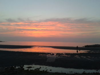 Scenic view of sea against orange sky