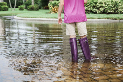 Young girl wearing purple boots in water