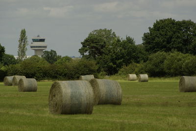 Hay bales on field against sky