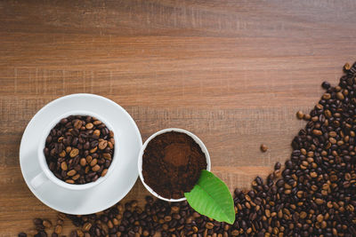 Directly above shot of ground coffee and beans on black table